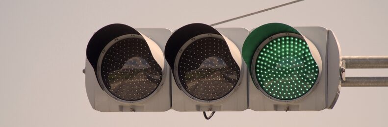 Ampel mit drei runden Lichtern; rechtes Licht leuchtet grün