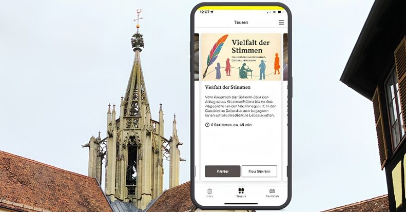 Kirchturmspitze und Smartphone mit Seite „Vielfalt der Stimmen“ im Vordergrund